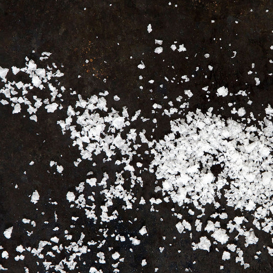 Icelandic flaky sea salt scattered on a surface, demonstrating the crunchiness and mineral richness of Saltverk's artisanal salt